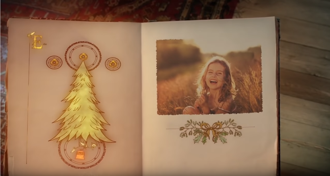 list od mikołaja kadr z filmu, księga po lewej stronie choinka, po prawej uśmiechnięta dziewczynka